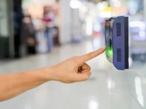 Karyawan menggunakan mesin absensi fingerprint di kantor