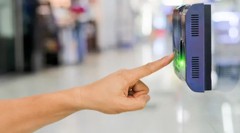 Karyawan menggunakan mesin absensi fingerprint di kantor
